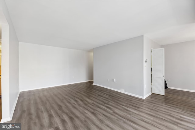 interior space featuring baseboards and dark wood-style flooring