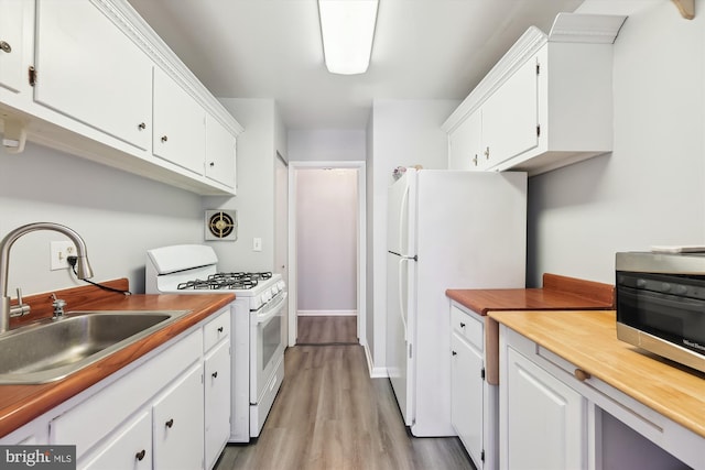 kitchen with visible vents, light wood-style floors, white appliances, white cabinetry, and a sink