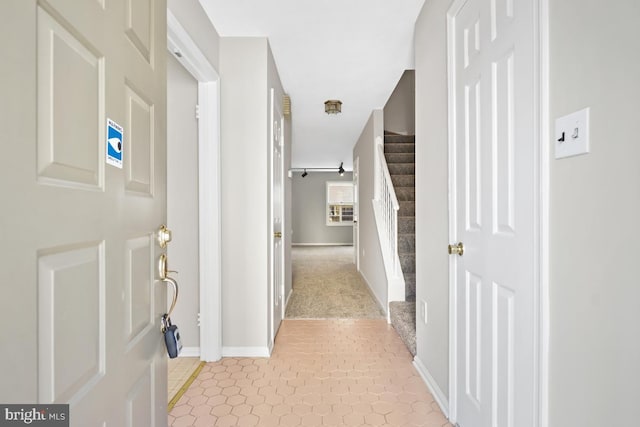 hallway with stairway and baseboards