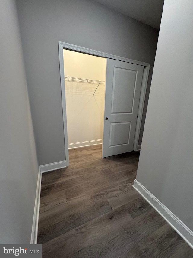 hall featuring wood finished floors and baseboards