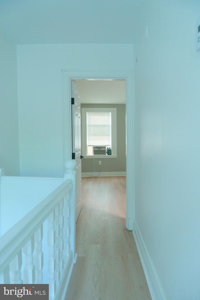 hallway with cooling unit, light wood-style floors, and baseboards