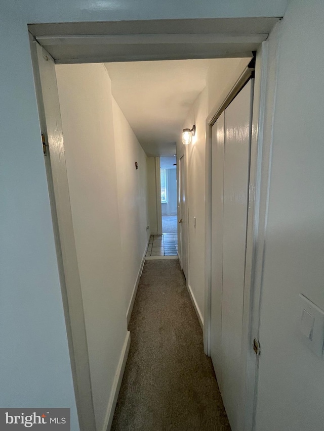 hallway featuring carpet flooring and baseboards