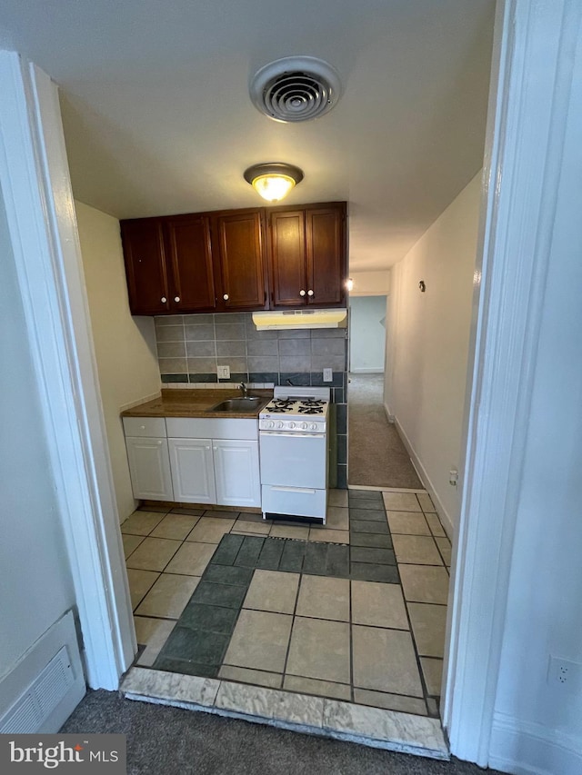 kitchen with under cabinet range hood, visible vents, gas range gas stove, and a sink