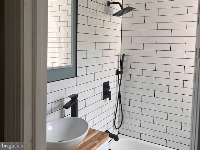 full bathroom with a sink, shower / bath combination, and tile walls