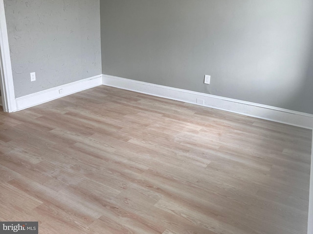 empty room with wood finished floors and baseboards