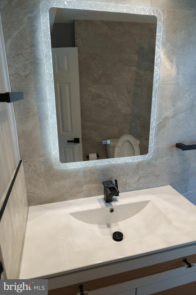 bathroom featuring backsplash, tile walls, and vanity