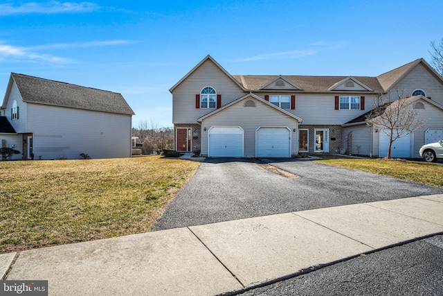 view of front of property featuring a front lawn, an attached garage, brick siding, and driveway