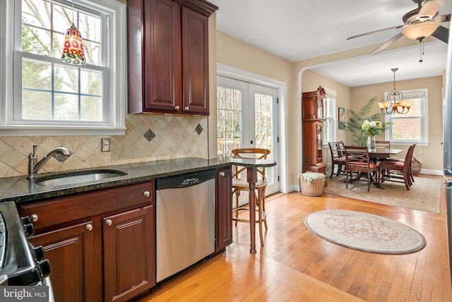 kitchen featuring backsplash, light wood-type flooring, stainless steel dishwasher, stove, and a sink