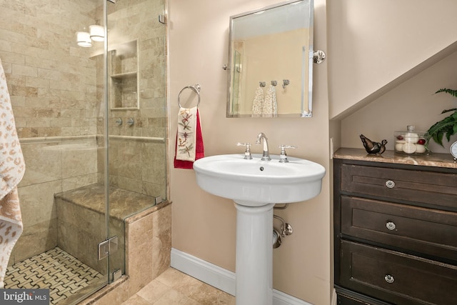 bathroom featuring baseboards, a stall shower, and tile patterned flooring