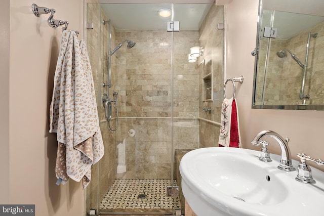 bathroom featuring a stall shower and a sink