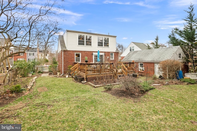 rear view of house with a yard, fence, brick siding, and a wooden deck