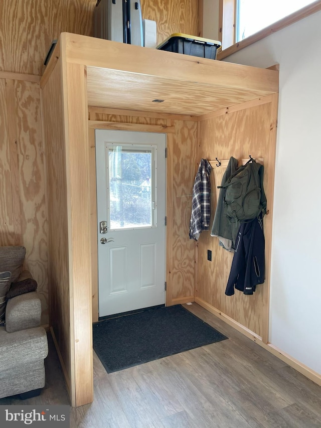 doorway featuring stairway, baseboards, and wood finished floors