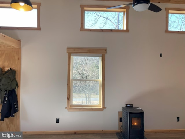 spare room with a wood stove, baseboards, and ceiling fan