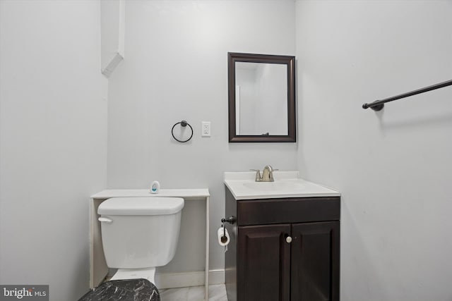 bathroom featuring vanity, toilet, baseboards, and marble finish floor