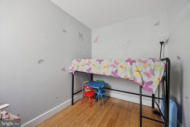 bedroom featuring baseboards and wood-type flooring