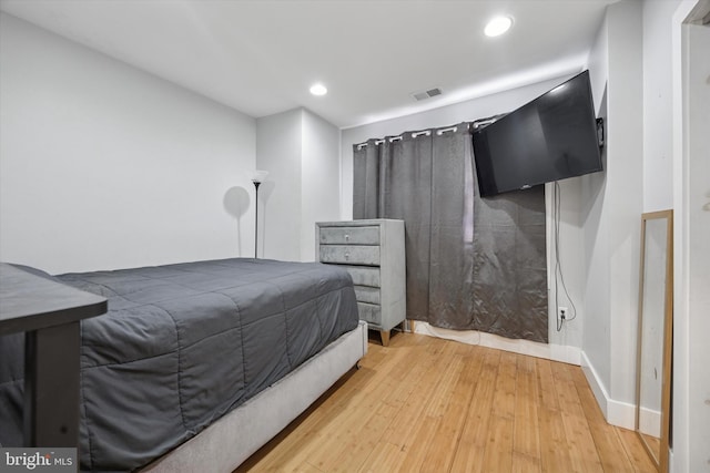 bedroom with light wood-type flooring, visible vents, baseboards, and recessed lighting