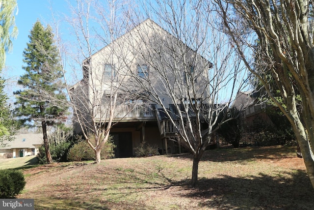 view of front of home featuring stucco siding, a wooden deck, and a front lawn