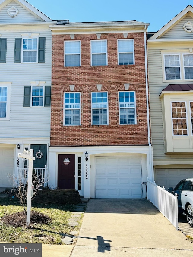 townhome / multi-family property featuring a garage, brick siding, and concrete driveway