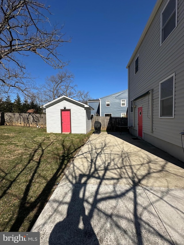 exterior space with an outbuilding, a fenced backyard, and a patio area