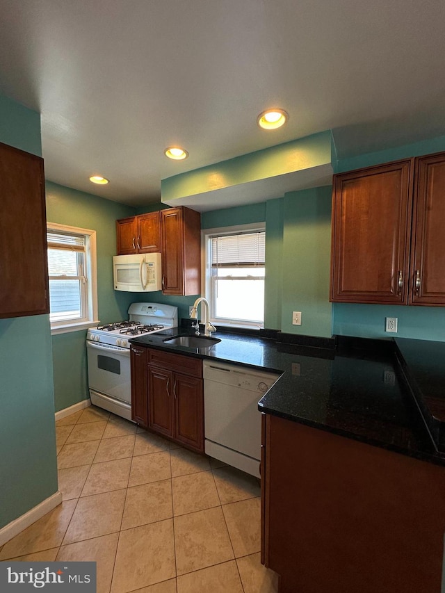 kitchen featuring white appliances, light tile patterned floors, recessed lighting, and a sink