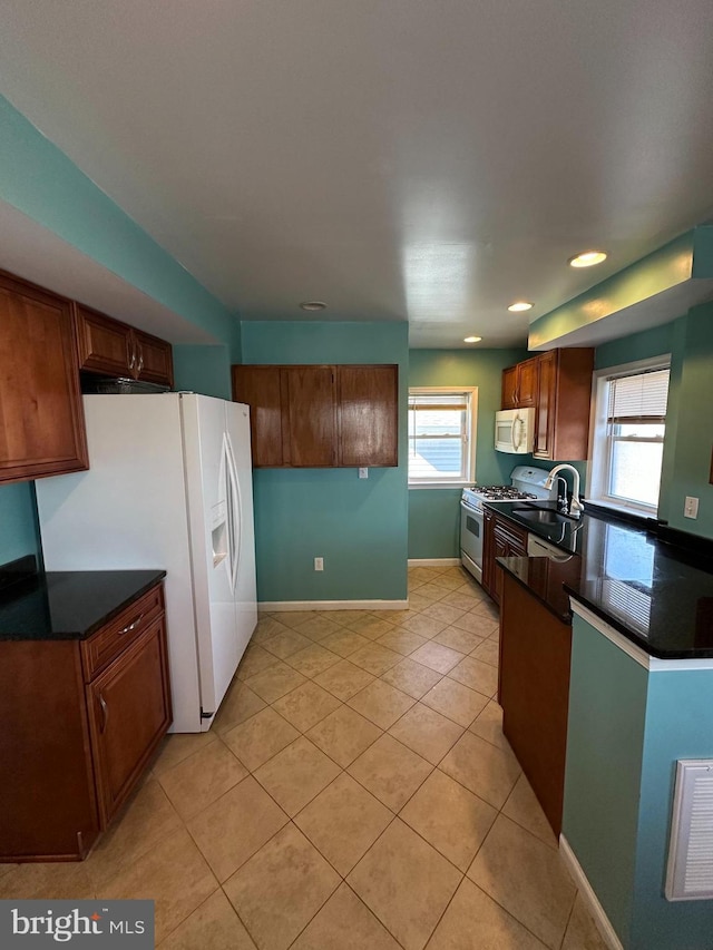 kitchen with dark countertops, plenty of natural light, and white appliances