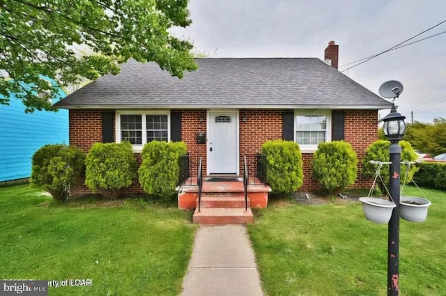 bungalow with brick siding, a front lawn, and a shingled roof