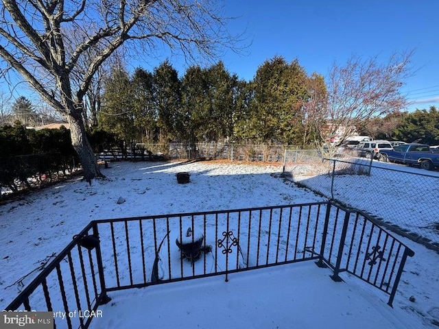 yard covered in snow featuring fence