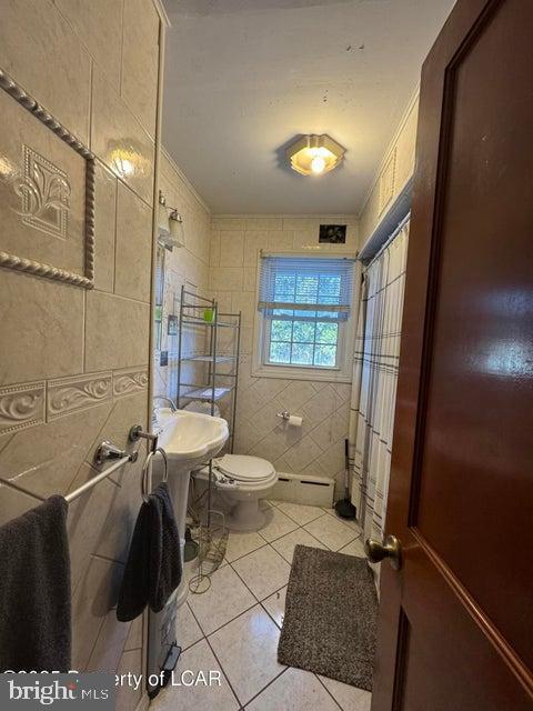 bathroom with tile patterned flooring, visible vents, toilet, tile walls, and a baseboard radiator