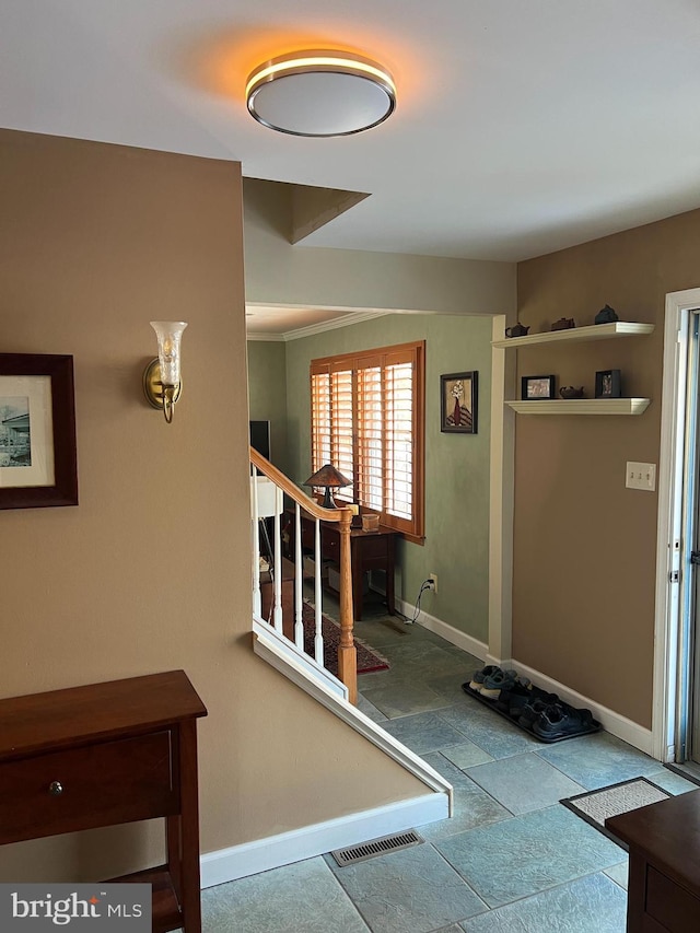 entryway with stairs, baseboards, visible vents, and stone tile flooring