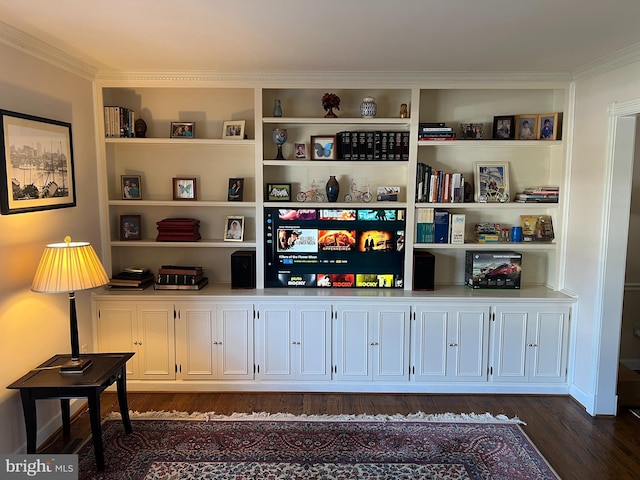 interior space with dark wood-style floors, built in shelves, and crown molding