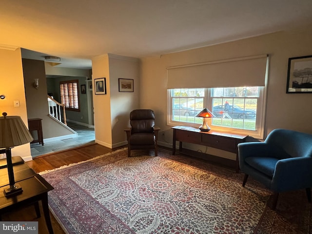 living area with stairway, a healthy amount of sunlight, baseboards, and wood finished floors