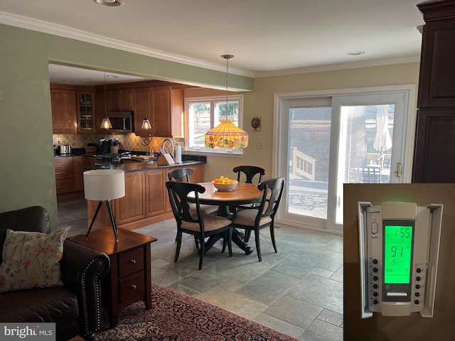 dining room with stone finish floor and ornamental molding