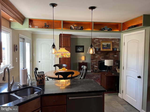 kitchen featuring a sink, dark stone counters, and decorative light fixtures