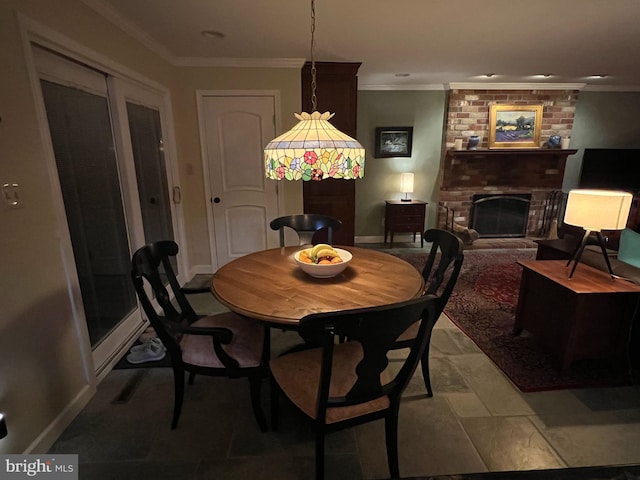 dining room featuring a fireplace, crown molding, and baseboards