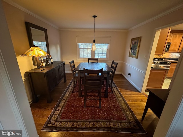 dining room featuring baseboards, ornamental molding, and dark wood-style flooring