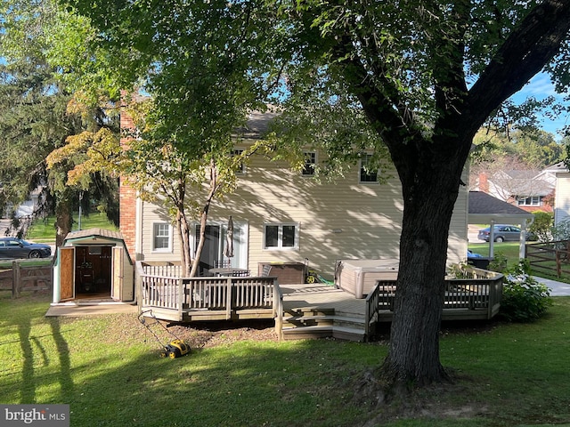 rear view of property with an outbuilding, fence, a wooden deck, a yard, and a storage shed