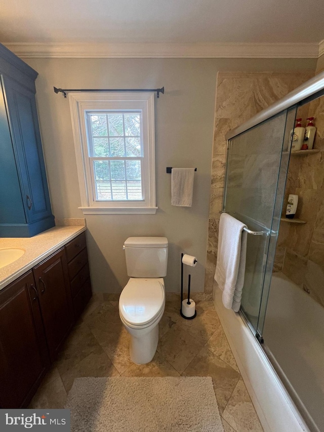 bathroom with vanity, crown molding, toilet, and bath / shower combo with glass door