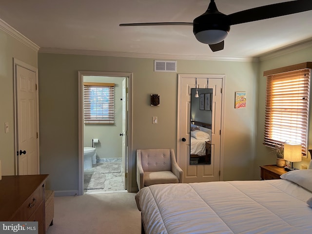 carpeted bedroom with ceiling fan, visible vents, ensuite bath, and crown molding