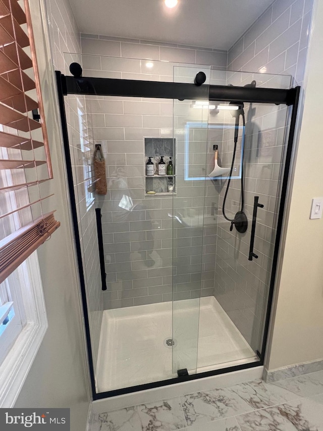 bathroom featuring a shower stall and marble finish floor