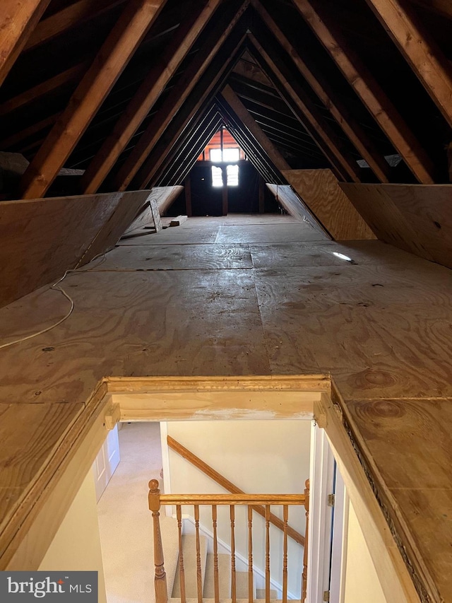 unfinished attic with an upstairs landing