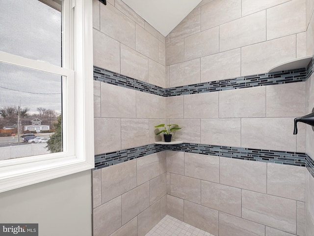 bathroom featuring tiled shower and vaulted ceiling