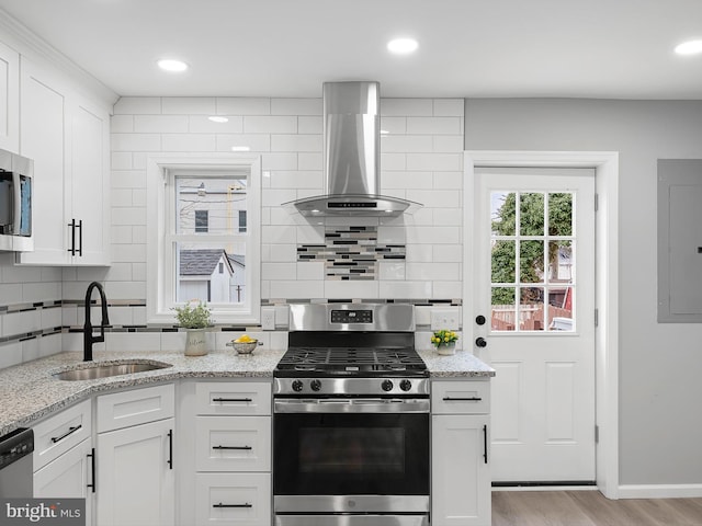 kitchen featuring ventilation hood, electric panel, decorative backsplash, stainless steel appliances, and a sink