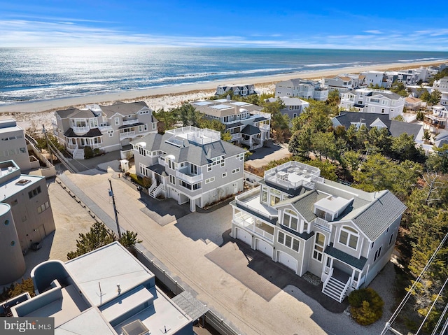 aerial view with a residential view, a view of the beach, and a water view