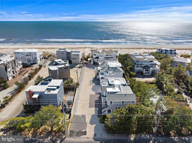 drone / aerial view featuring a view of the beach, a residential view, and a water view