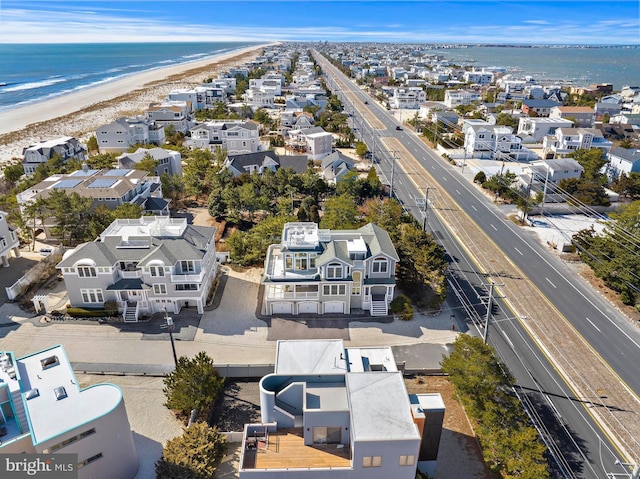 drone / aerial view with a residential view, a view of the beach, and a water view