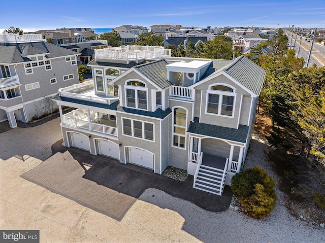 view of front of house featuring a balcony, a residential view, and driveway