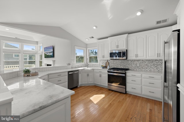 kitchen with white cabinetry, vaulted ceiling, visible vents, and appliances with stainless steel finishes