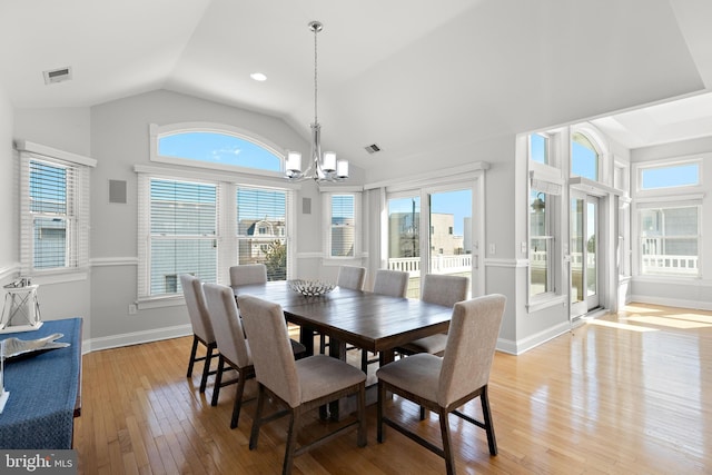 dining room featuring light wood-type flooring, plenty of natural light, and lofted ceiling