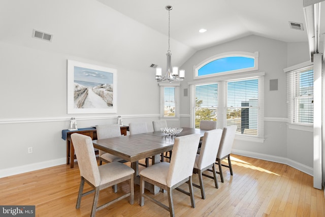 dining room with light wood-type flooring, visible vents, a notable chandelier, baseboards, and lofted ceiling