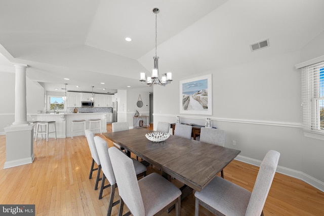 dining room with vaulted ceiling, visible vents, a wealth of natural light, and decorative columns